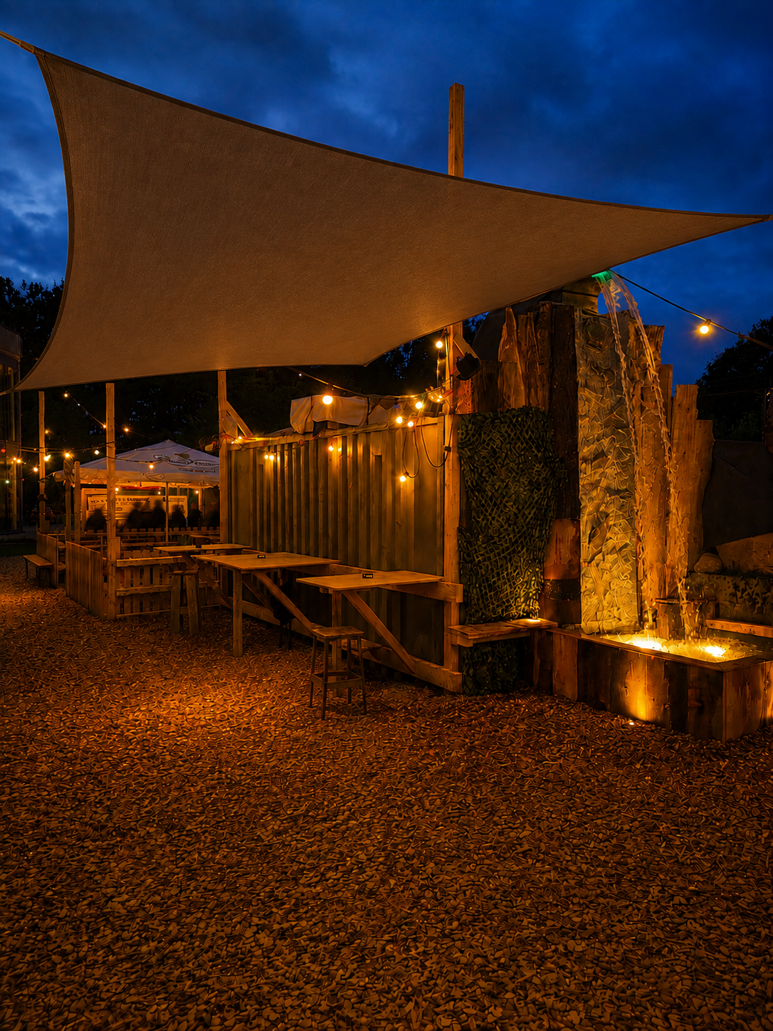 Jesteburg Alm am Abend mit Sonnensegel, Wasserfall und warmen Lichterketten